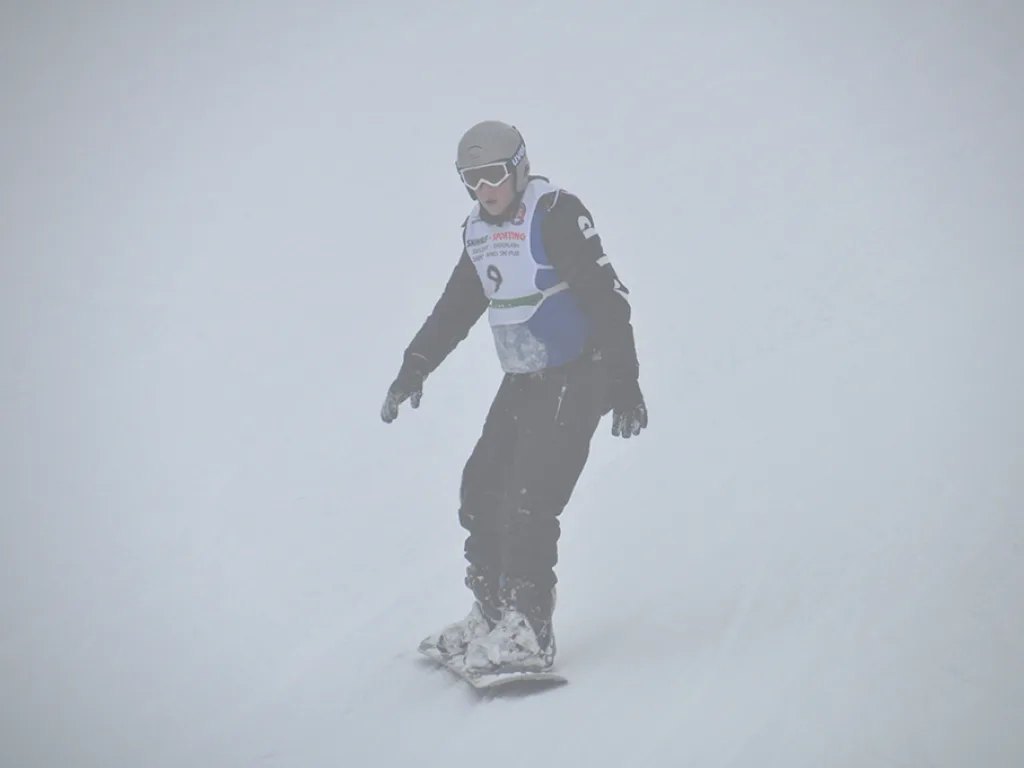 Snowboarder mit Startnummer 9 im Nebel.